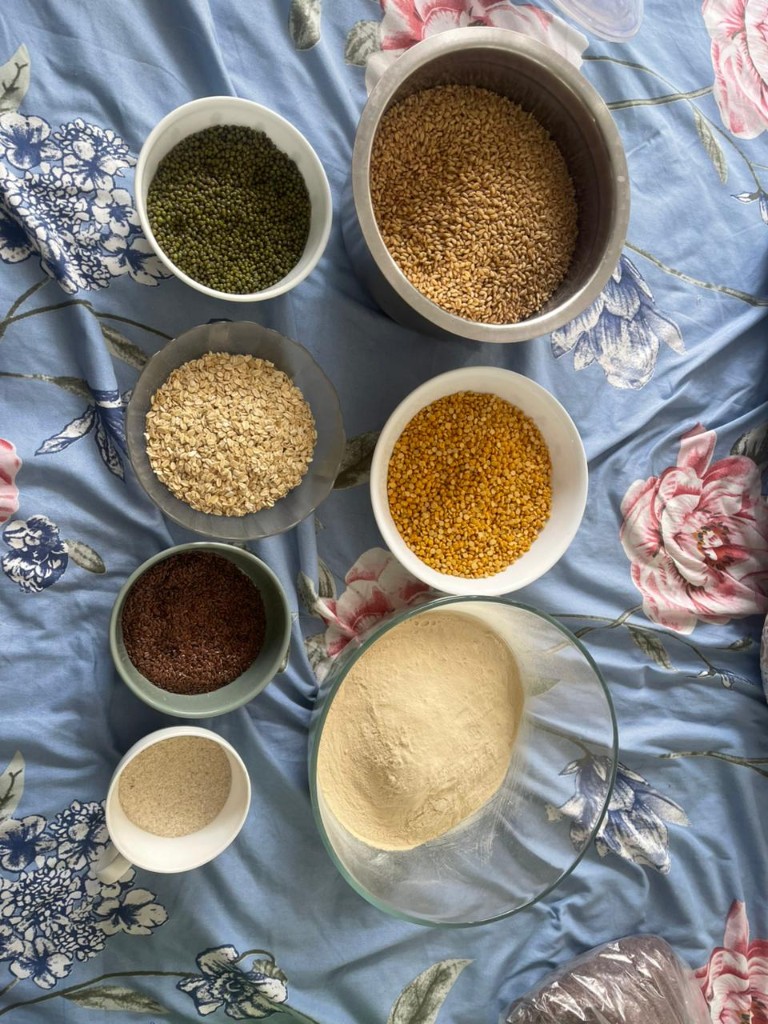 Bowls of whole mung, wheat, oats, chana dal, flaxseed, and milled flour